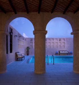 an outdoor pool in a building with two arches at Souq Waqif Boutique Hotels - Tivoli in Doha