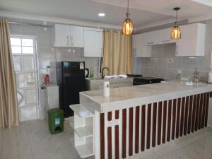 ナニュキにあるMG's Nest Two-bedroom all-ensuite bnb - private compoundのキッチン(黒い冷蔵庫、白いキャビネット付) +5枚の写真