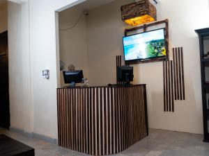 a flat screen tv on a wall next to a counter at La Vieja Habana Zona Colonial in Santo Domingo