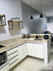 a kitchen with white cabinets and a counter top at Dunas residence casa 15- Lençois Maranhense in Santo Amaro +42 photos