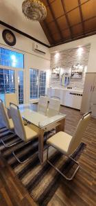 a dining room with a table and white chairs at فلة و شاليه واسع بمسبح وثلاث غرف نوم ومجلس شعبي ومجلس مناسبات in Riyadh
