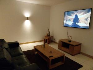 Una sala de estar con un sofá y un televisor en la pared. en Tity Apartments T1 - Perfect Stay on your Holiday, en Santa Maria