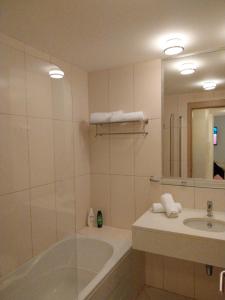 Un baño con bañera, lavabo y espejo. en Tity Apartments T1 - Perfect Stay on your Holiday, en Santa Maria