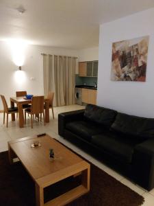 Una sala de estar con un sofá negro y una mesa. en Tity Apartments T1 - Perfect Stay on your Holiday, en Santa Maria