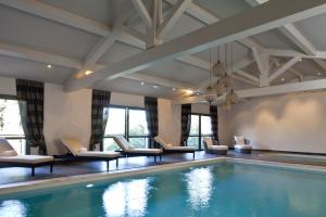 a swimming pool in a hotel room with chairs at Le Vallon de Valrugues & Spa in Saint-Rémy-de-Provence