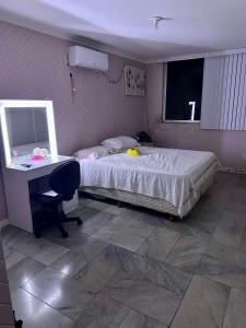 a bedroom with a bed and a desk and a mirror at Alugo apartamento 1 por andar no centro de Belém para o COP30 in Belém
