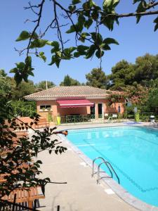 uma piscina com uma casa ao fundo em Résidence Fior di Rena em Saint-Florent