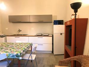 Una pequeña cocina con una mesa y un refrigerador. en Appartamento con piccolo giardino Cannero Riviera, en Cannero Riviera