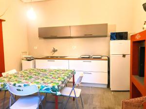 Una pequeña cocina con una mesa y un refrigerador. en Appartamento con piccolo giardino Cannero Riviera, en Cannero Riviera 22 fotos más