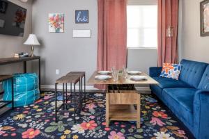 a living room with a blue couch and a table at Little Rock - Cozy Downtown Retreat in Little Rock