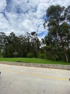 a road with a green field and trees at House in Miraflores Cuenca in Cuenca
