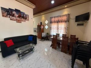 a living room with a couch and a dining room at Arana Holiday Resort in Kurundankulama