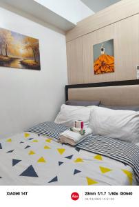 a bedroom with a bed with a yellow and blue comforter at Condo unit in Manila