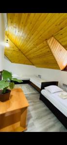 two beds in a room with a wooden ceiling at Жайсан in Karakol