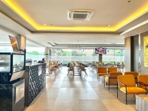 a restaurant with chairs and tables and a bar at LYNN Hotel Tuban in Tuban