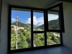 ein Fenster mit Blick auf einen Berg in der Unterkunft Жайсан in Karakol