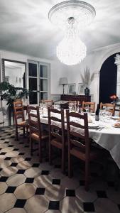 a dining room with a table with chairs and a chandelier at Gîte en Normandie avec piscine in Rugles