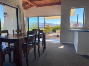a kitchen and dining room with a table and chairs at Ridgehouse Wanaka in Wanaka +9 photos