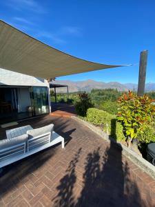 a white couch sitting on a brick patio at Ridgehouse Wanaka in Wanaka