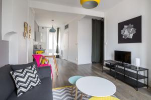 ein Wohnzimmer mit einem Sofa und einem Tisch in der Unterkunft Appartement Lyon Villeurbanne - Enjoy in Lyon in Villeurbanne