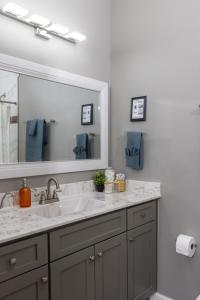 a bathroom with a sink and a large mirror at Little Rock Hideaway Cozy, Chic & Convenient in Little Rock