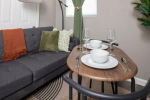 a living room with a couch and a wooden table with glasses at Little Rock Hideaway Cozy, Chic & Convenient in Little Rock +21 photos