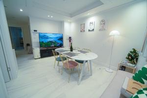a living room with a table and chairs and a television at Stay Busan in Busan