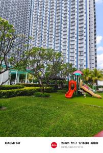 a playground in a park in front of a large building at Condo unit open for staycation in Manila