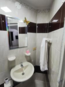 une salle de bain avec un lavabo et un miroir dans l'établissement Imbanaco Centro Medico Apartamento Estadio, à Cali