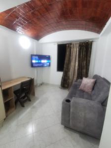 un salon avec un canapé et un bureau dans l'établissement Imbanaco Centro Medico Apartamento Estadio, à Cali
