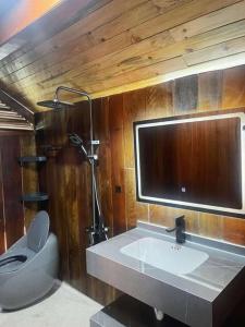 une salle de bain avec un lavabo, des toilettes et un miroir dans l'établissement Pơ Lang Farmstay, à Bien Ho