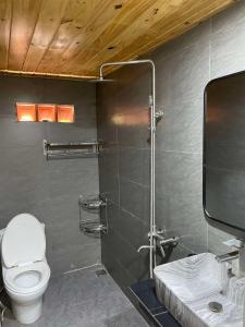 une salle de bain avec toilettes et douche dans l'établissement Pơ Lang Farmstay, à Bien Ho