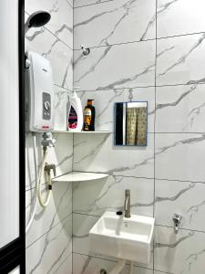 a white bathroom with a sink and a mirror at Rozie Cozy,Merlimau 6-8pax 3Bedrooms2Bathrooms single storey terrace house in Merlimau +3 photos