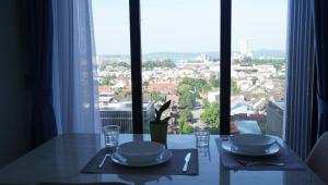 a dining table with a view of a city from a window at Blue Belle Staycation Pollux Habibie in Batam Center