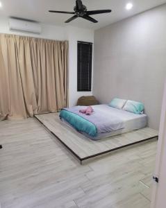 a bed in a bedroom with a ceiling fan at Setia Indah Setia Alam 3bedrooms House 8-10pax Next to Setia City Mall in Shah Alam
