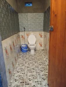 a bathroom with a toilet with a tiled floor at Black Hmong Sapa Homestay Family in Sa Pa