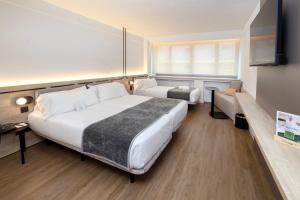 Una cama o camas en una habitación de Sercotel Delfos Andorra