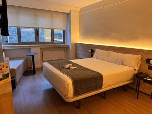 Una cama o camas en una habitación de Sercotel Delfos Andorra