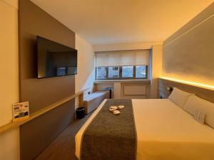 Una cama o camas en una habitación de Sercotel Delfos Andorra