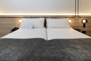 Una cama o camas en una habitación de Sercotel Delfos Andorra