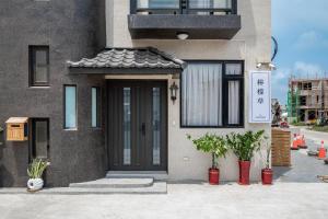 a house with a black door and plants in front of it at 澎湖檸檬草 Easy Stay in Magong