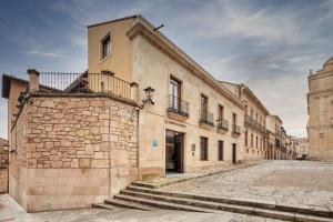 a stone building with stairs on the side of it at Sercotel Puerta de la Catedral in Salamanca