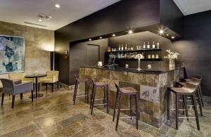 a bar in a restaurant with stools and tables at Sercotel Puerta de la Catedral in Salamanca