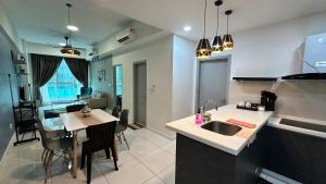 Sutera Avenue KK Near Imago by Kita Homestay في كوتا كينابالو: مطبخ وغرفة معيشة مع حوض وطاولة