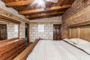 a bedroom with a large bed in a brick wall at Family Chalet in Villa Vicente 4 Bedrooms in San Miguel Balderas