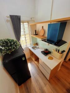 胡志明市FlexiHome的厨房配有带水槽和冰箱的书桌