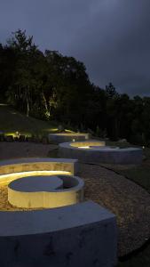 a group of concrete benches in a park at night at Camping do Bosque - Deck 01 in Rodeio +4 photos