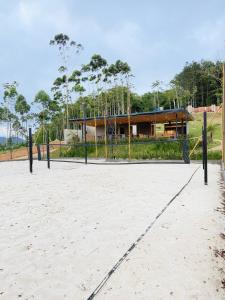 a volleyball court in front of a building at Camping do Bosque - Deck 01 in Rodeio