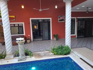 una piscina di fronte a un edificio con colonne di Villa Los Abuelos a Cozumel
