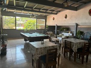 Una sala de estar con una mesa de billar y un sofá. en Casa veranera, en Quepos